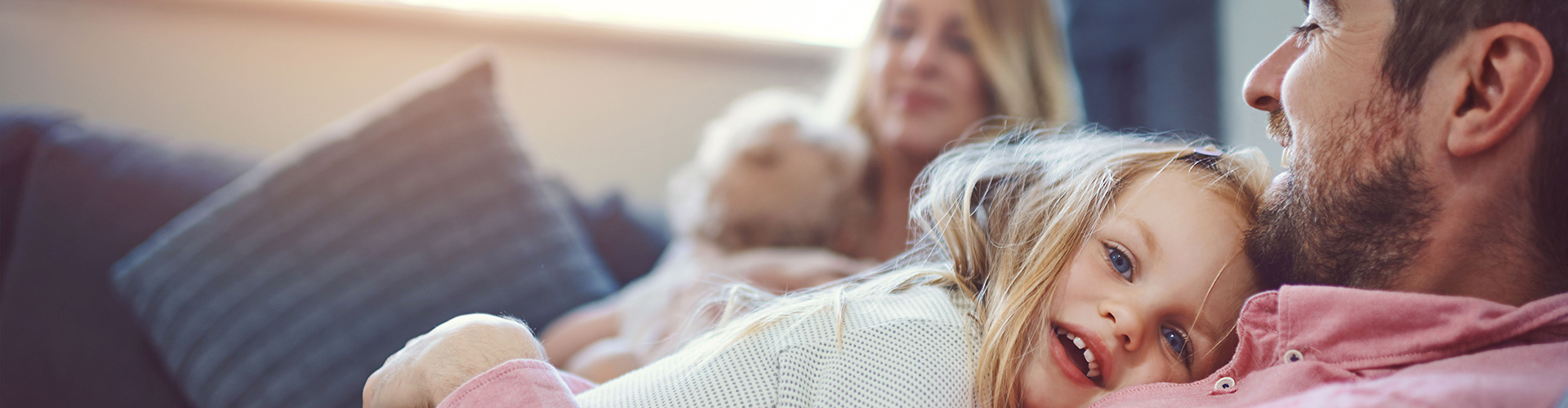 Vater kuschelt mit seiner Tochter auf der Couch