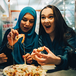 Zwei Freundinnen essen gemeinsam eine Pizza