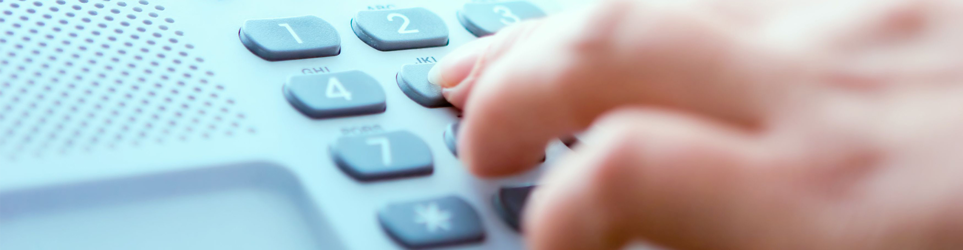 Hand wählt eine Nummer auf einem Telefon
